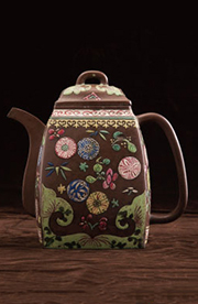 色鮮やかな花模様で装飾された茶色の陶製ティーポット